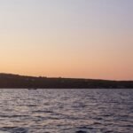 a body of water with a hill in the background